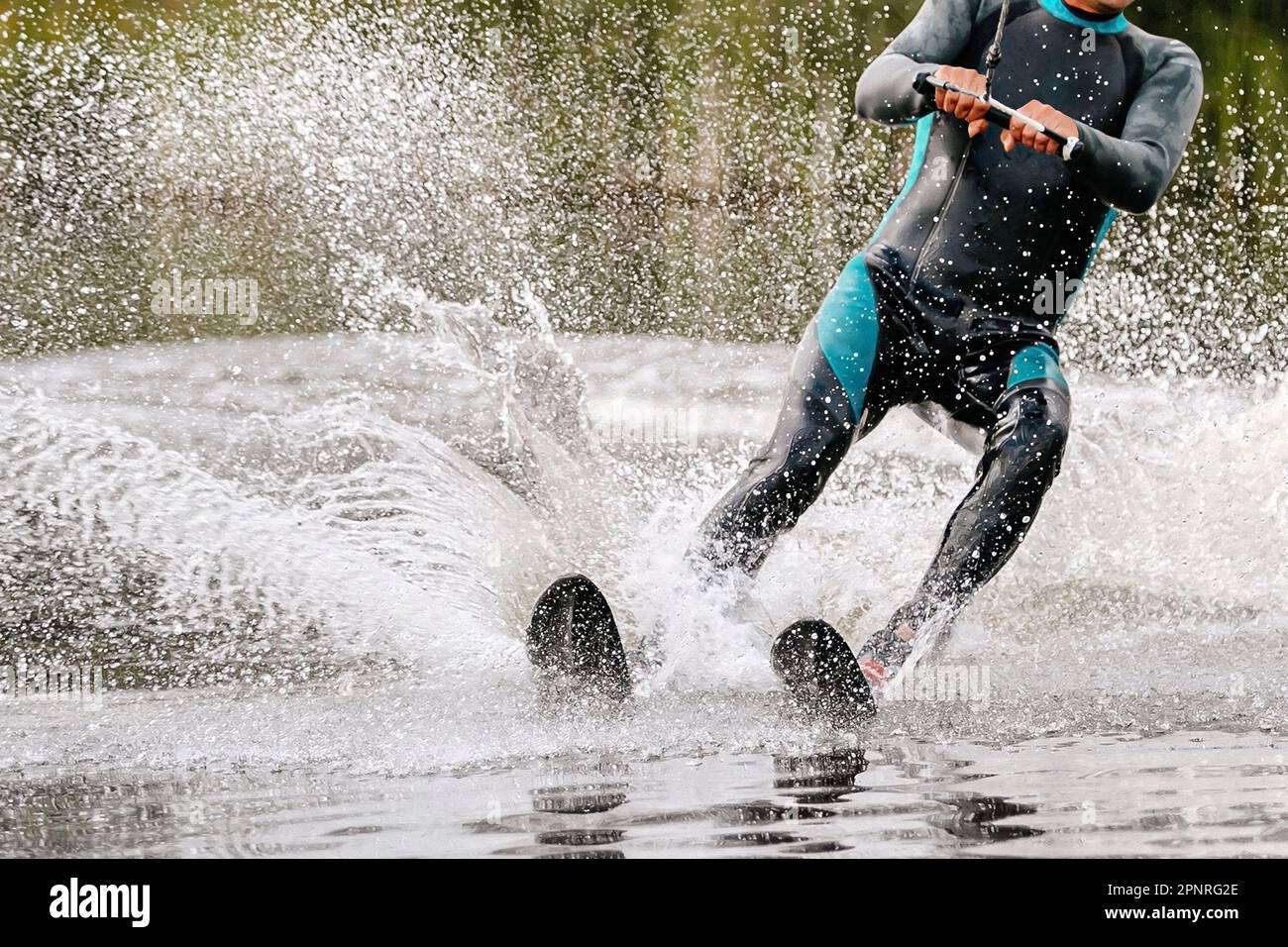 Wassersportler, die hinter einem Motorboot auf dem See Wasserski fahren, extreme Wassersportarten im Sommer Stockfoto