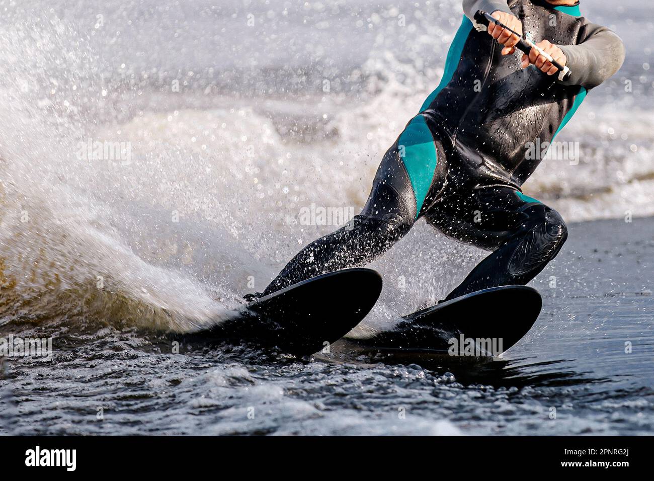 Sportler aus nächster Nähe, der Wasserski auf dem See fährt, extreme Wassersportarten im Sommer Stockfoto