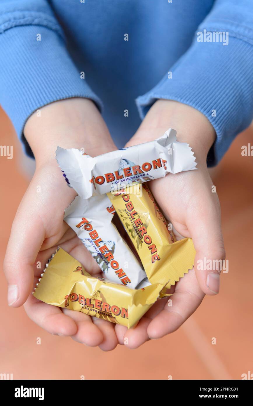 Arahal. Sevilla. Spanien. 18. März 2023. Nahaufnahme eines Kindes, das einen Schokoriegel der Marke Toblerone hält. Übermäßiger Konsum von Zuckerdose Stockfoto