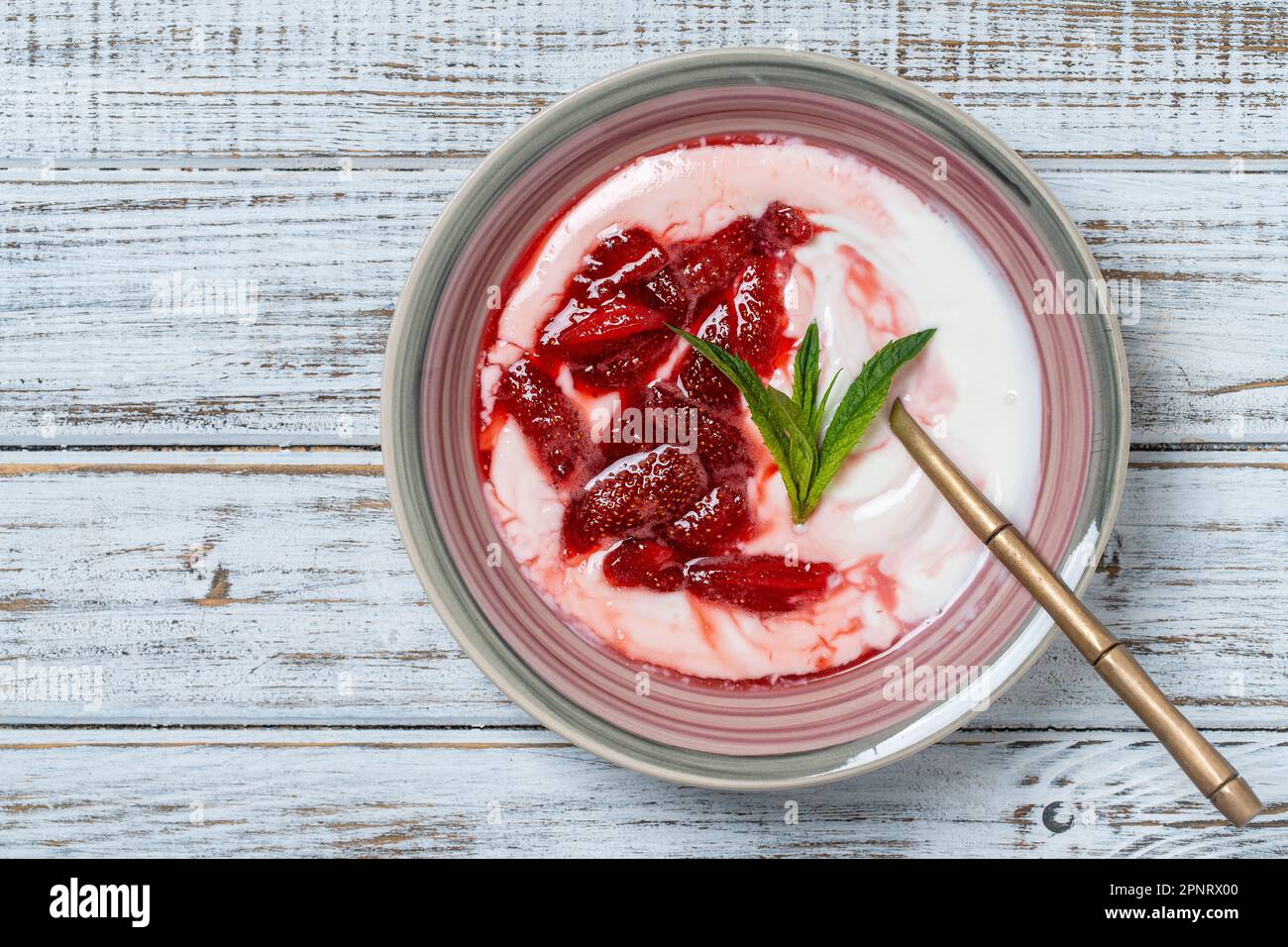 Weißer Teller mit roten Erdbeeren und natürlichem Joghurt auf einem Holztisch, Nahaufnahme, Draufsicht Stockfoto