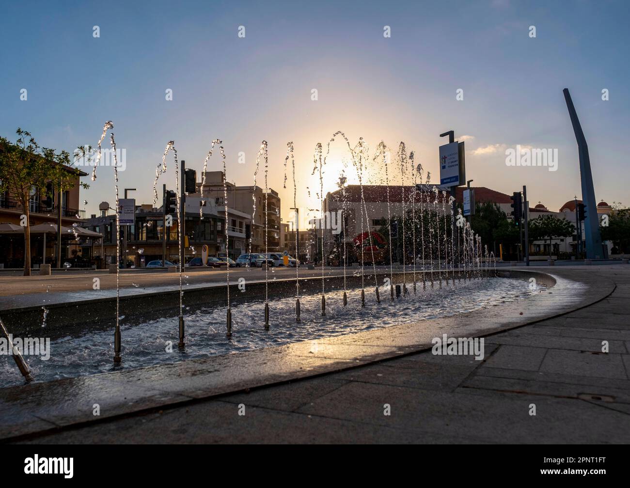 Die Sonne geht hinter dem Wasserbrunnen auf dem Kennedy Square, der Altstadt von Pafos, Zypern unter. Stockfoto