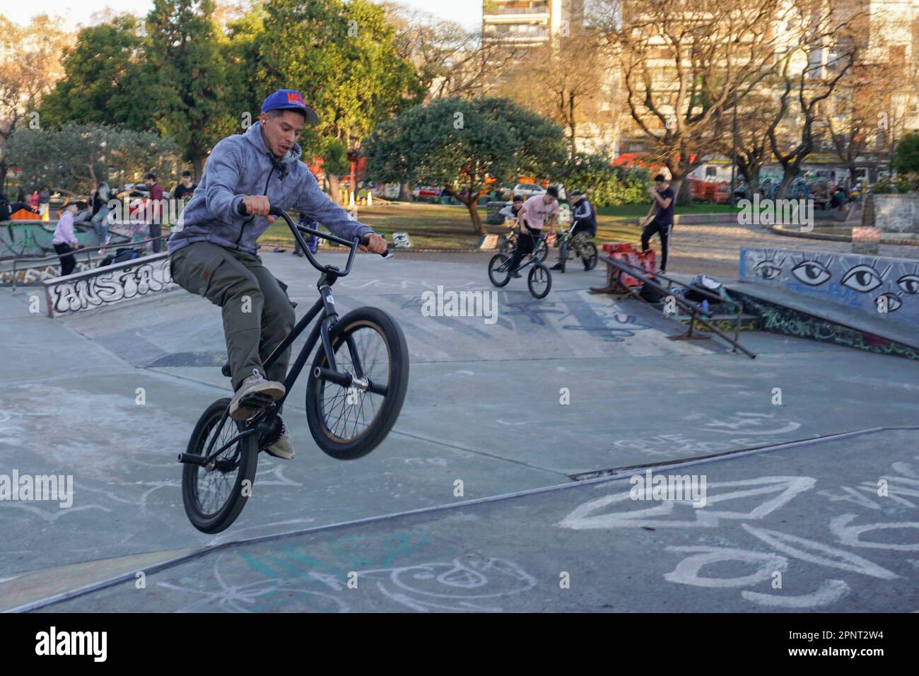 Fernando Nuñez dreht sich in der Luft auf seinem BMX-Fahrrad im Parque Centenario, Buenos Aires, Argentinien. Nuñez, der seit 10 Jahren BMX-Tricks praktiziert und vorführt, sagt, dass sich die Fahrer im Park treffen, um Tipps auszutauschen und sich gegenseitig neue Fähigkeiten beizubringen. (Lucila Pellettieri/Global Press Journal) Stockfoto