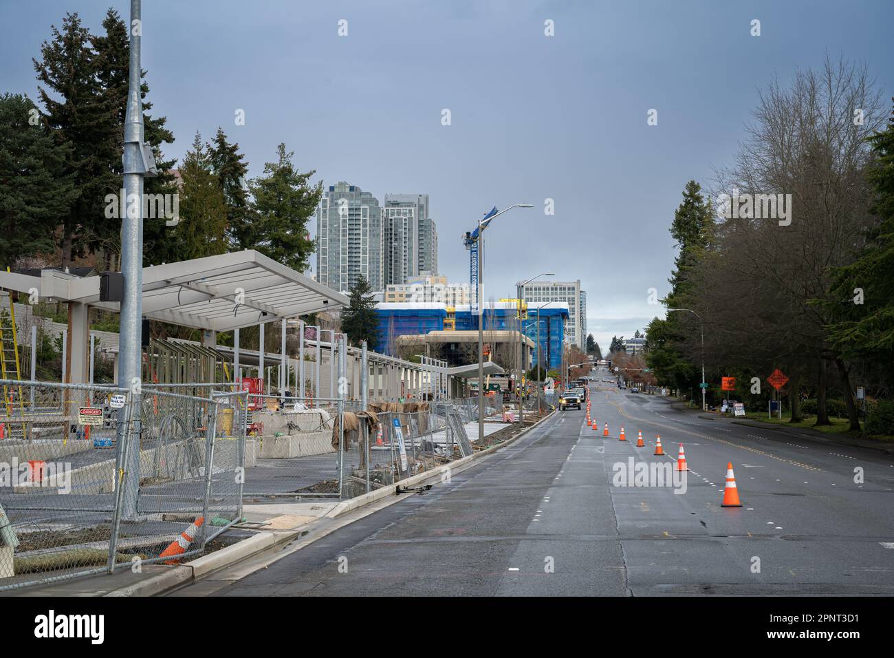 Blick auf eine Straße mit orangefarbenen Sicherheitskegeln und im Hintergrund mit den Gebäuden der Stadt Stockfoto