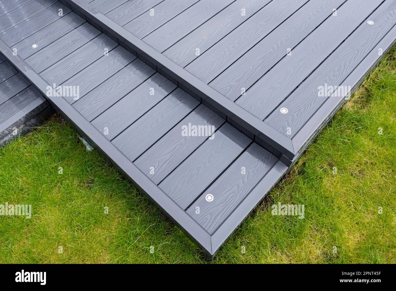Aschegraue Terrassendielen aus Verbundwerkstoff an einem regnerischen, nassen Tag zeigen die volle Maserung der Terrassendielen Und Ein gutes Hintergrundbild Stockfoto