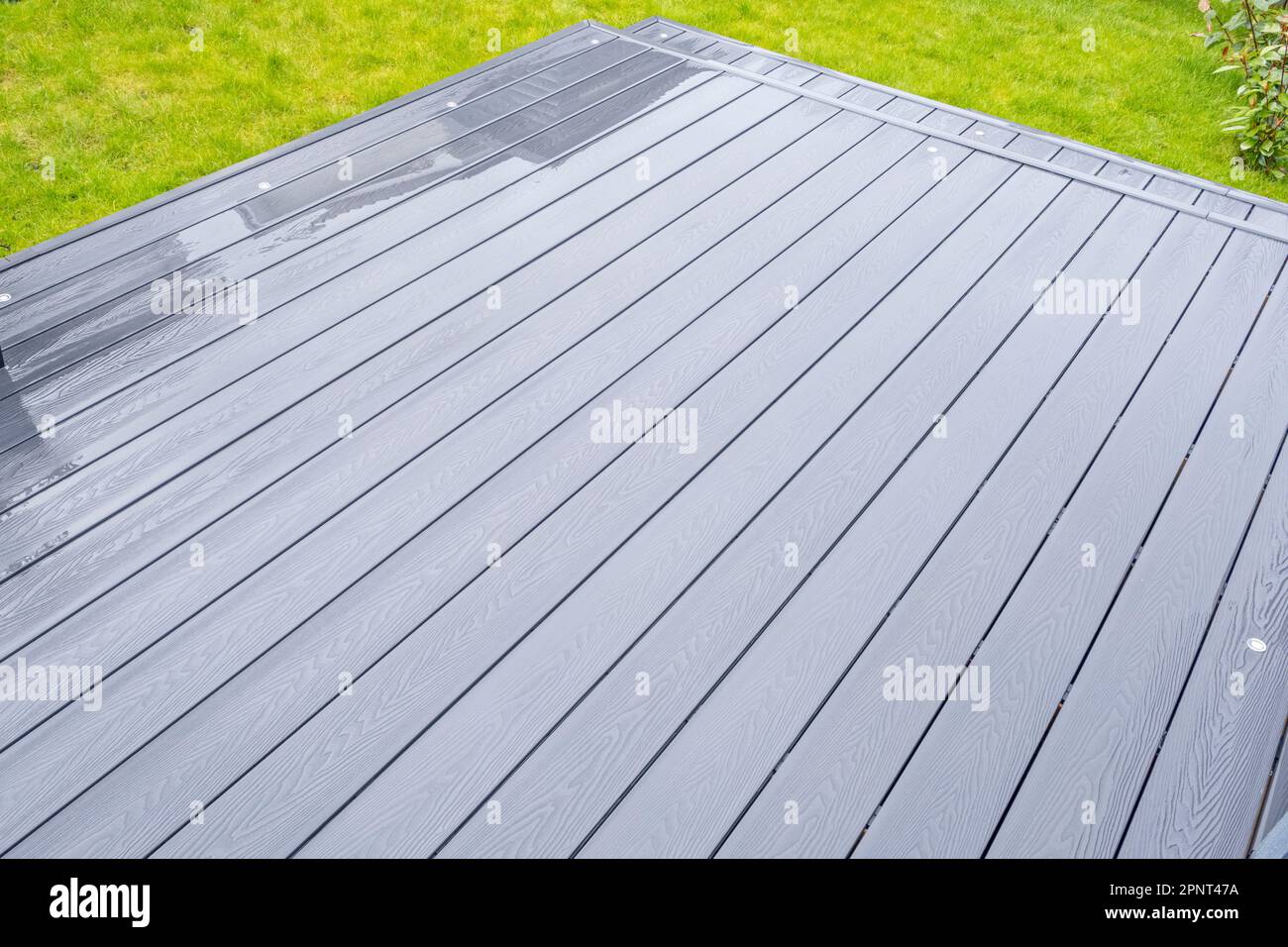 Aschegraue Terrassendielen aus Verbundwerkstoff an einem regnerischen, nassen Tag zeigen die volle Maserung der Terrassendielen Und Ein gutes Hintergrundbild Stockfoto