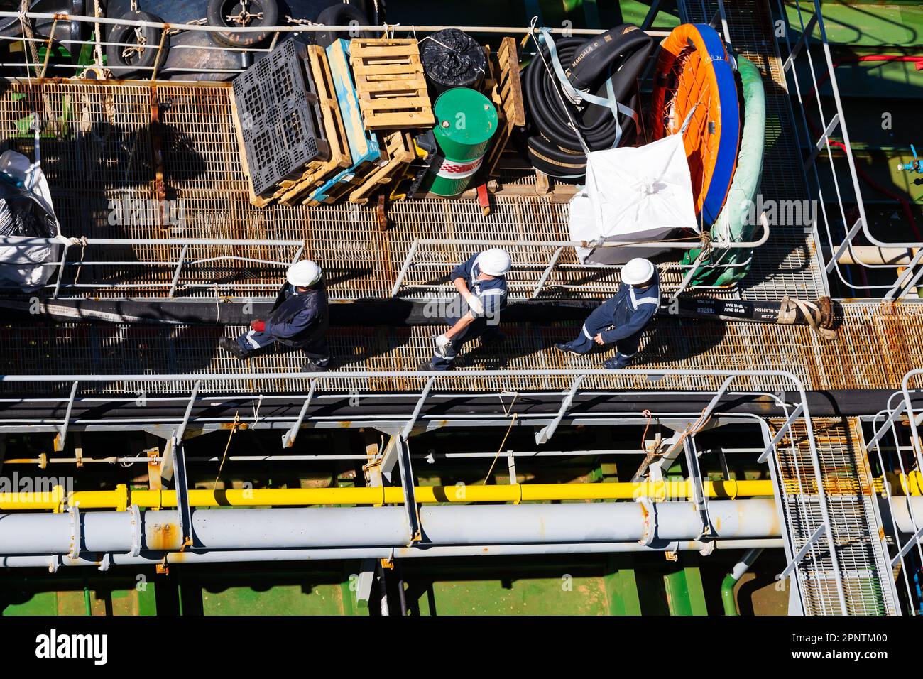 Offenes Deck des Tankschiff-Bulker-Service-Bootes bei der Arbeit. Rohrleitungen. Tankwagen, von oben. Laufsteg mit Crew. Stockfoto