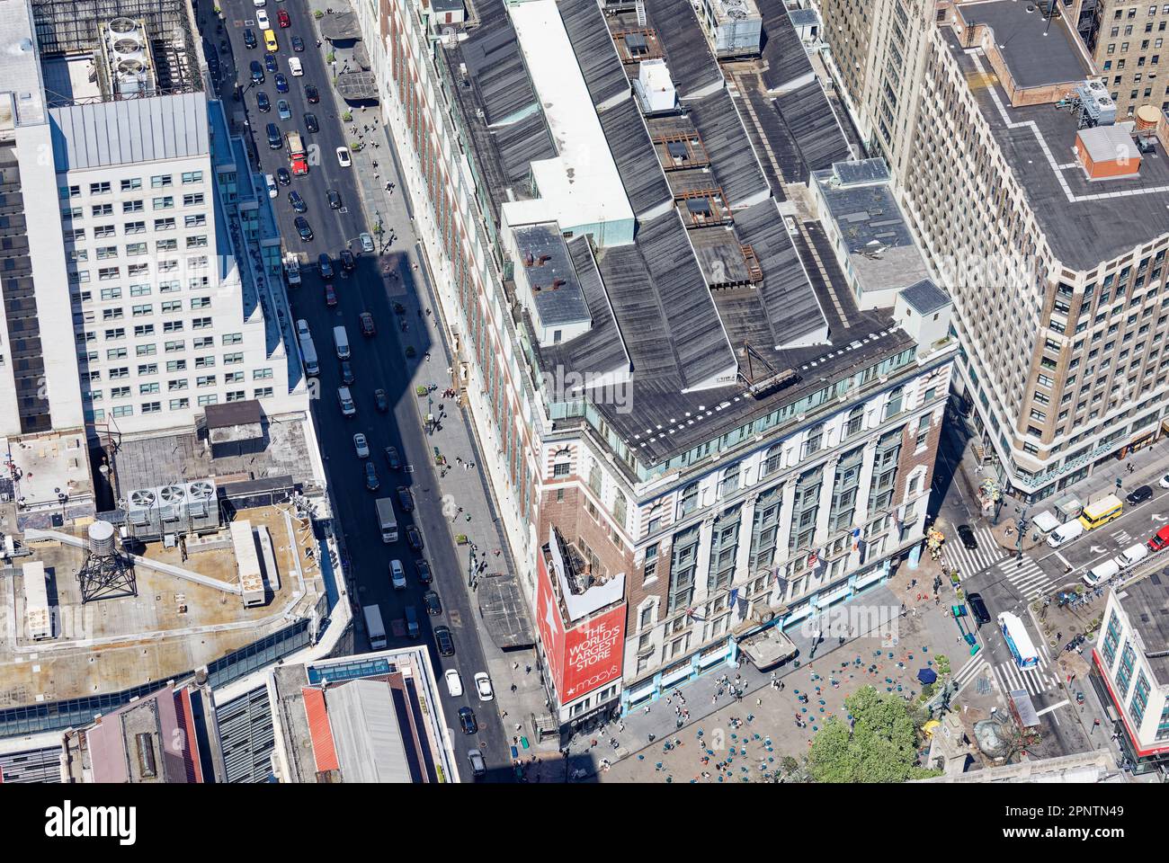 Macy's Herald Square, ein bekanntes Kaufhaus, hat nie das winzige Holdout in der Ecke erworben, obwohl sie eine dreistöckige Plakatwand managten. Stockfoto