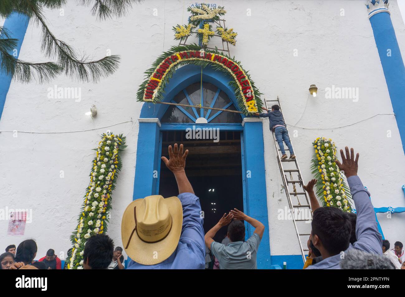 Ein Mann schmückt eine Kirche zur Feier der Heiligen Maria Magdalena, der schutzheiligen der Stadt seit 1883, in Aldama, Chiapas, Mexiko, am 19. Juli, 2022. (Marissa Revilla/Global Press Journal) Stockfoto
