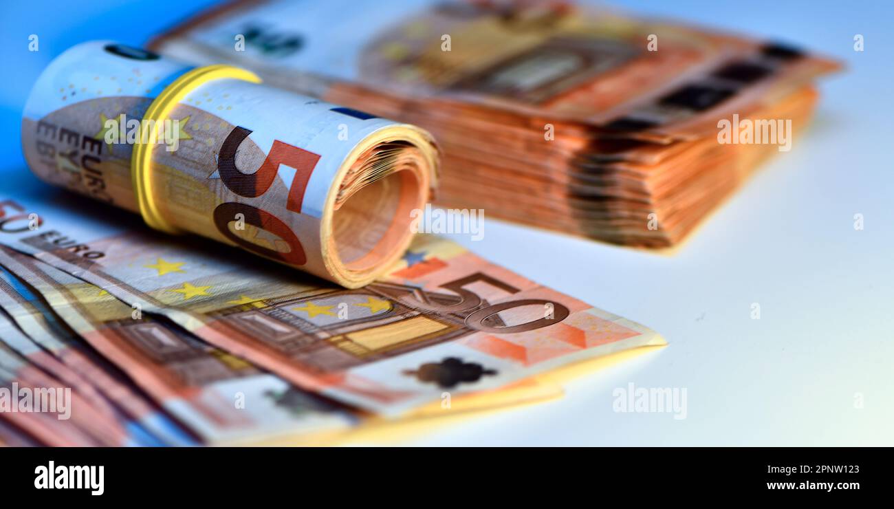 Konzept von vielen Euro: Ein Stapel gerollter 50-Euro-Scheine, die auf weißem Hintergrund liegen und Tausende von Euro in 50-Euro-Scheinen darstellen Stockfoto