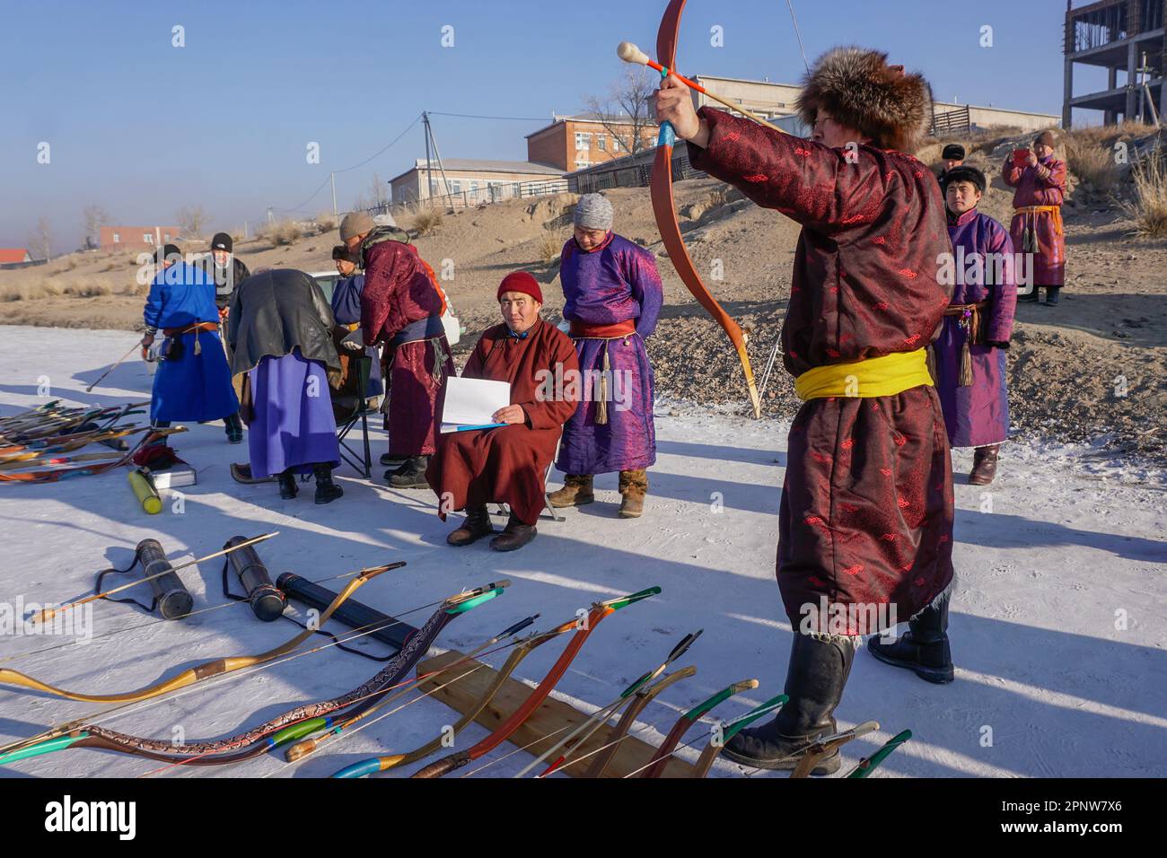 Chinbat Gonchigjamts, richtig, richtet einen Bogen während eines Provinzturniers in Uriankhai, einer von drei Arten traditioneller mongolischer Bogenschießen, auf einen gefrorenen Fluss in Murun, Provinz Khuvsgul, Mongolei am 9. Januar 2022. In diesem Wettbewerb, der zur Förderung des Nationalsports und zur Vorbereitung des Naadam-Festivals im Sommer veranstaltet wird, beurteilen Bogenschützen die Leistungen des jeweils anderen. (Dolgormaa Sandagdorj/Global Press Journal) Stockfoto