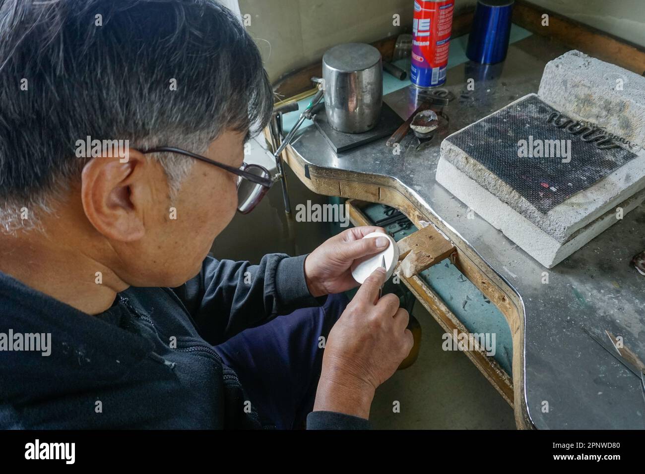 Ganbaatar Gantulga bedeckt eine Badarhundaga-Steinschüssel mit Silber in Ulaanbaatar, Mongolei am 22. August 2022. Ganbaatar sagt: „Bei der Herstellung von Produkten mit der Hand widme ich meinen äußersten Augenfertigkeiten, meinen geistigen Fähigkeiten und meinen Handfertigkeiten und achte auf jedes Detail.“ (Odonchimeg Batsukh/Global Press Journal) Stockfoto