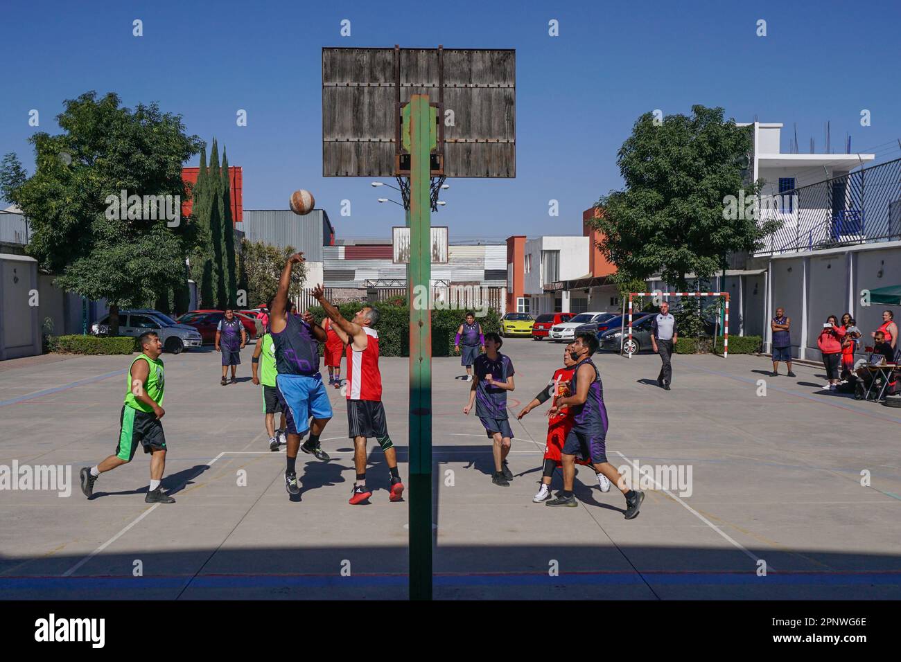 Mitglieder der Teams Ráfaga und Halcones spielen am 27. Februar 2022 in Tecámac, Mexiko, Basketball. Die Teams bereiten ihre Uniformen und Ausrüstung unabhängig vor und versammeln sich jeden Sonntag zu lokalen Turnieren. (Aline Suárez del Real/Global Press Journal) Stockfoto