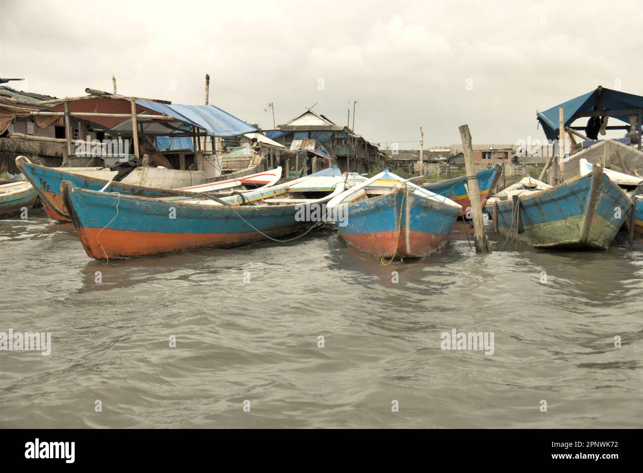 Holzboote sind an der Seite des Kanals am traditionellen Hafen Sunda Kelapa in Penjaringan, Nord-Jakarta, Jakarta, Indonesien angebunden. Stockfoto