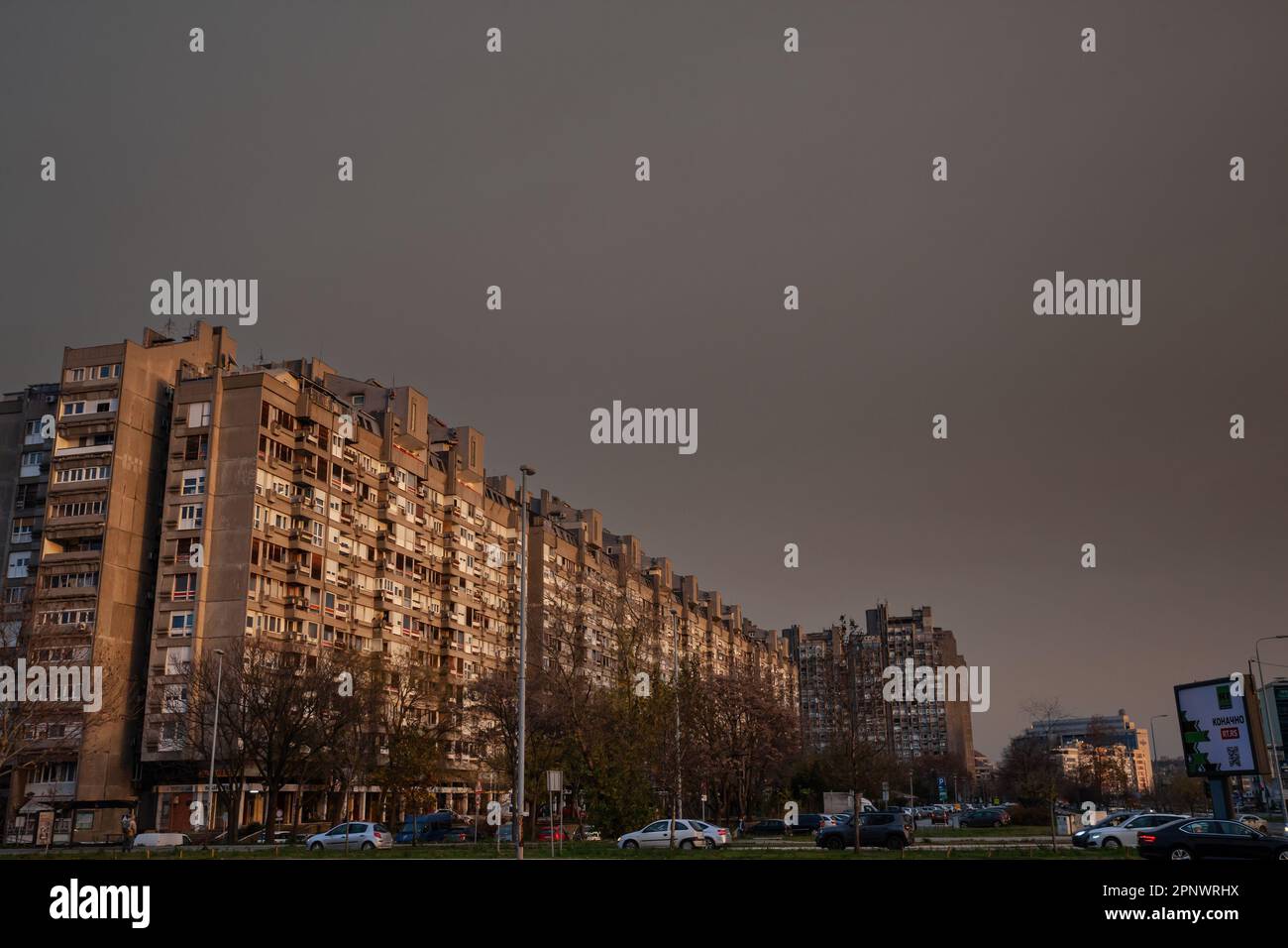 Bild der sozialistischen Gebäude von Novi Beograd im Blok 23 in Belgrad, Serbien, mit Autos und Menschen, die vorbeifahren. Sie sind typisch für die kommunistischen Archi Stockfoto