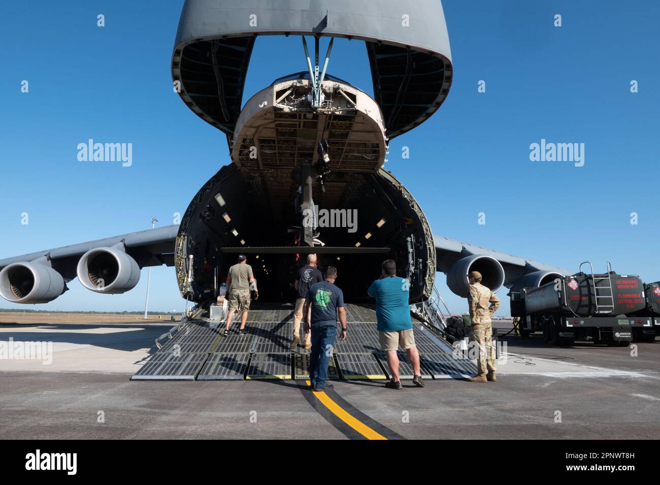 Mitglieder des Joint Force Service und Personal des MacDill Air Force Base, laden Sie einen 5. Bataillon, 159. Luftfahrtregistriment UH-60 Black Hawk Hubschrauber auf ein C-5 Super Galaxy Flugzeug vom 436. Airlift Wing, Dover AFB, auf die Fluglinie am MacDill AFB, Florida, 20. April 2023. Die C-5 landete in MacDill, um die UH-60 zu unterstützen. Beide Flugzeuge werden während des Dyess Big Country Air Fest 2023, das für den 22. April 2023 geplant ist, als statische Ausstellungsstücke präsentiert. (USA Air Force Foto von Staff Sgt. Shannon Bowman) Stockfoto