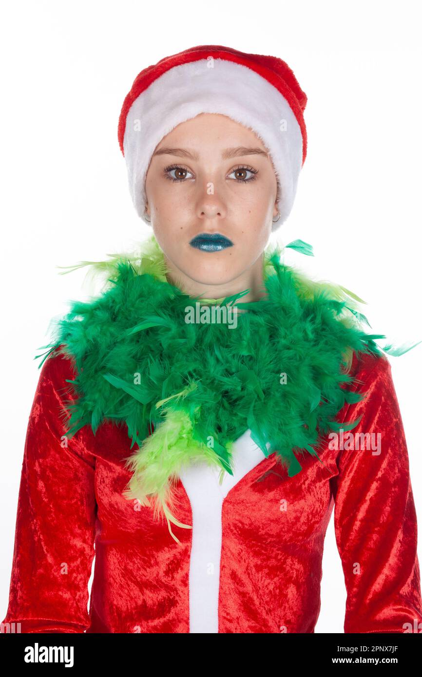 Nahaufnahme eines ausdruckslosen jungen Mädchens mit roter weihnachtsmannmütze, weihnachtsgrinch isoliert auf weißem Hintergrund. Negative menschliche Emotionen Stockfoto