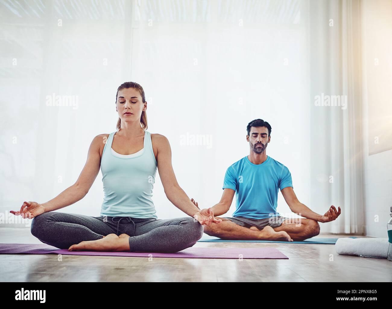 Lernen, loszulassen und Intimität zu erleben. Ein Paar, das zu Hause Yoga praktiziert. Stockfoto