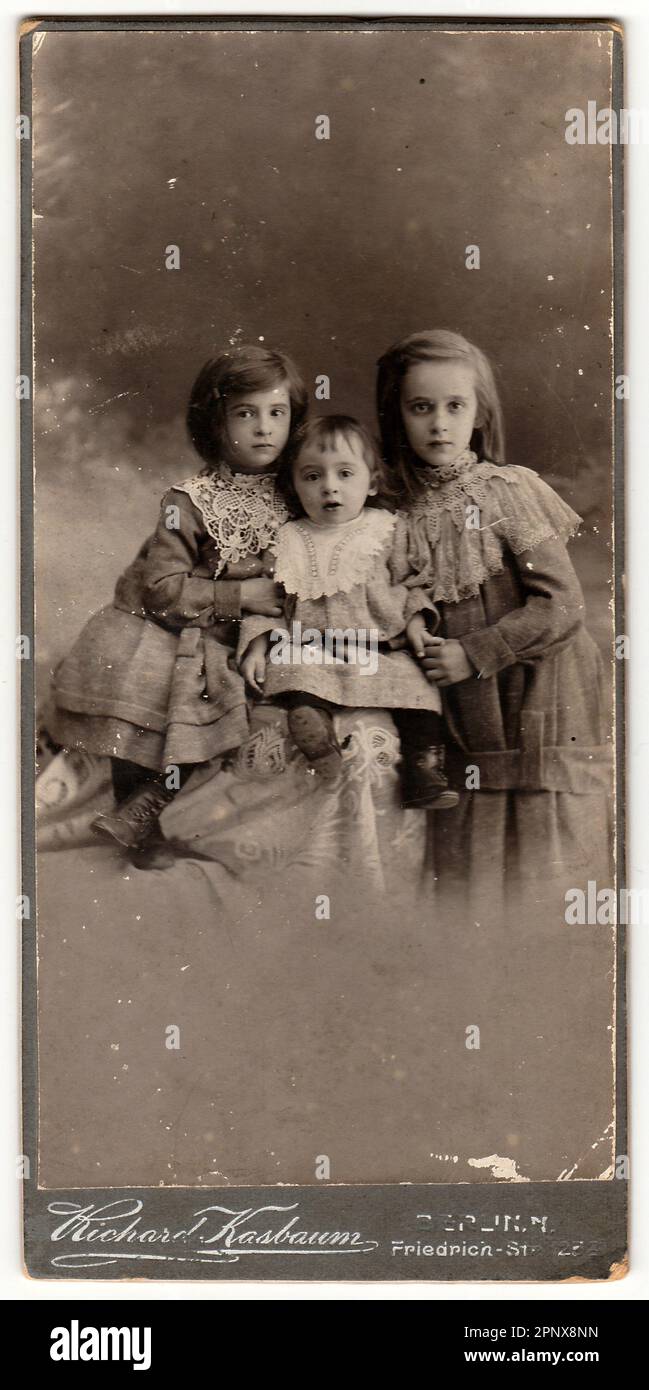 Eine alte Schrankkarte zeigt süße Kinder Mädchen. Antikes Schwarzweißfoto. Stockfoto