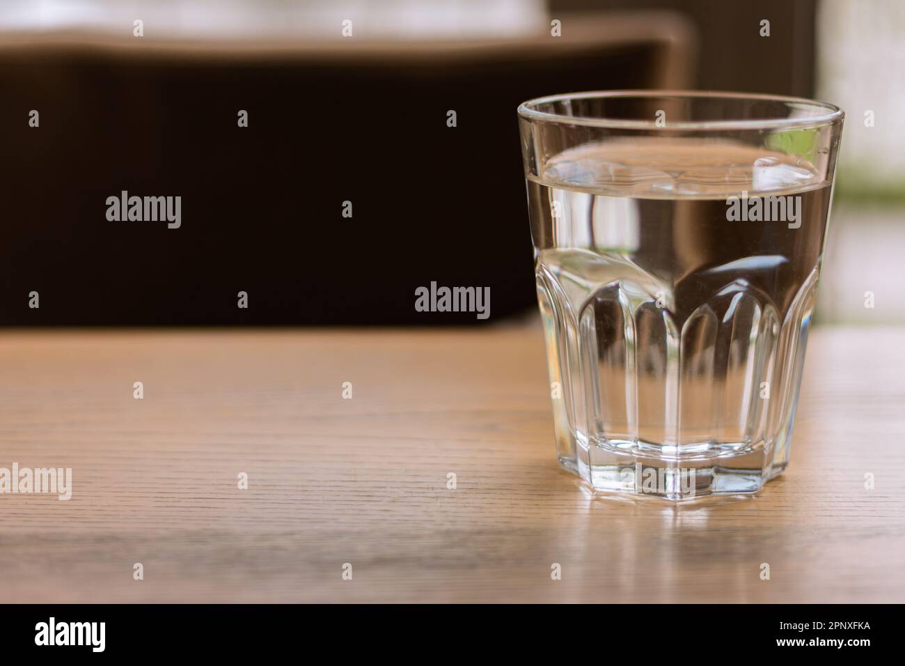 Ein Glas Wasser auf dem Tisch. Klares Wasser. Durstbegriff. Reinheit Hintergrund. Kalte Getränke. Gesunder Lebensstil. Sauberes Getränk. Gesunde Ernährung. Stockfoto