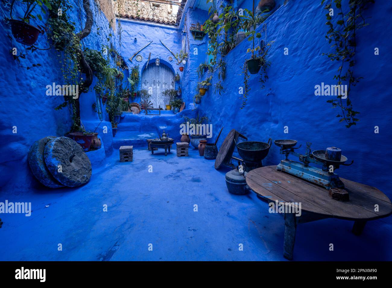 Blaue Terrasse mit traditionellen Objekten in einer engen Straße in Chefchaouen. Stockfoto