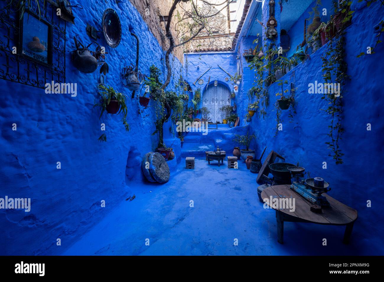 Blaue Terrasse mit traditionellen Objekten in einer engen Straße in Chefchaouen. Stockfoto
