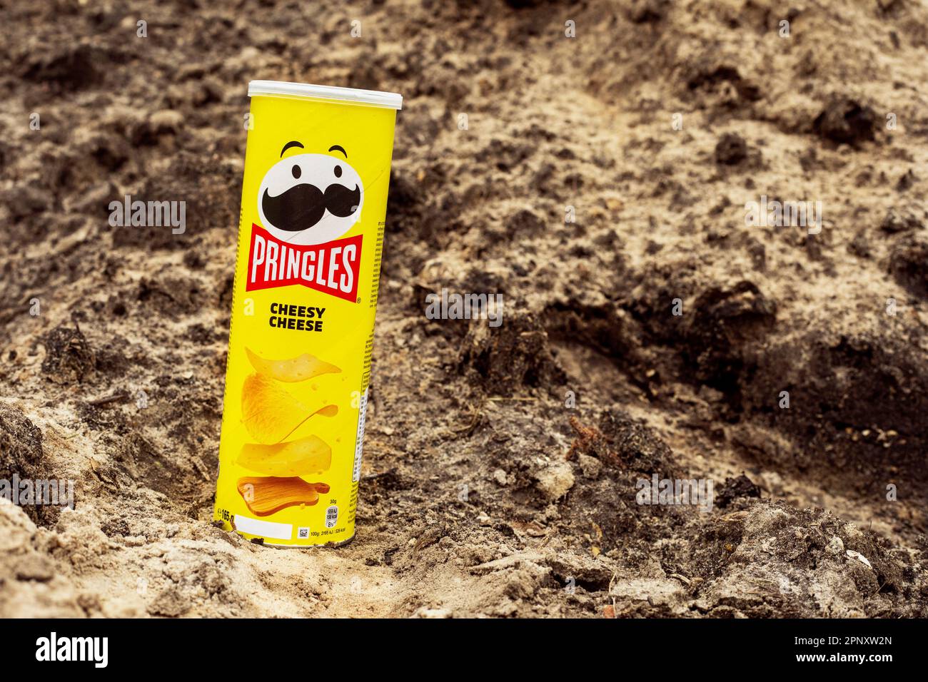 Pringles Chips mit Käse in einem gelben Paket wurden am 19. April 2023 in der Ukraine vor dem Hintergrund von Sand in einem privaten Innenhof eingenommen Stockfoto