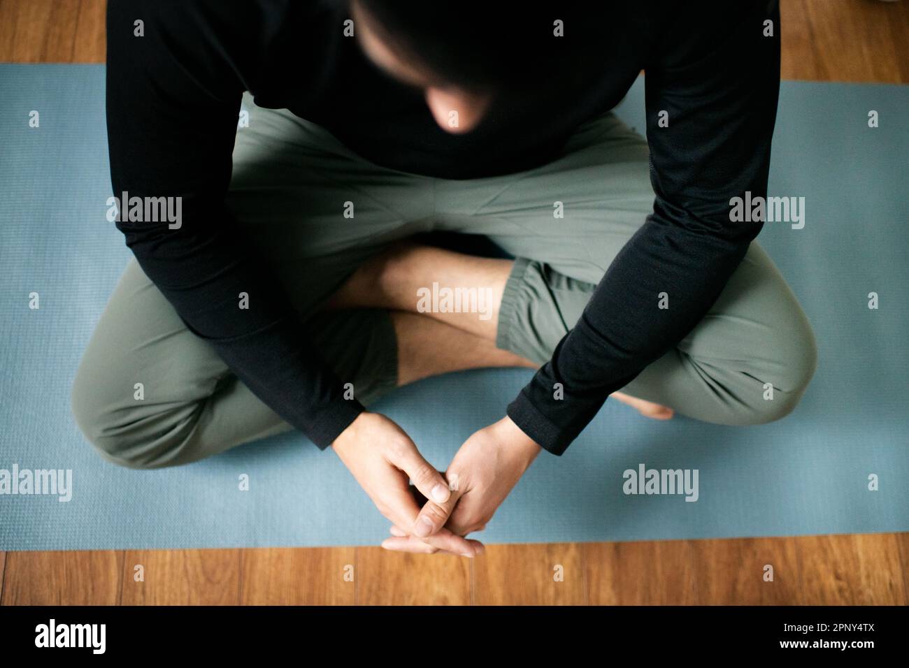 Foto des jungen Mannes, der auf Yoga Mat meditiert Stockfoto