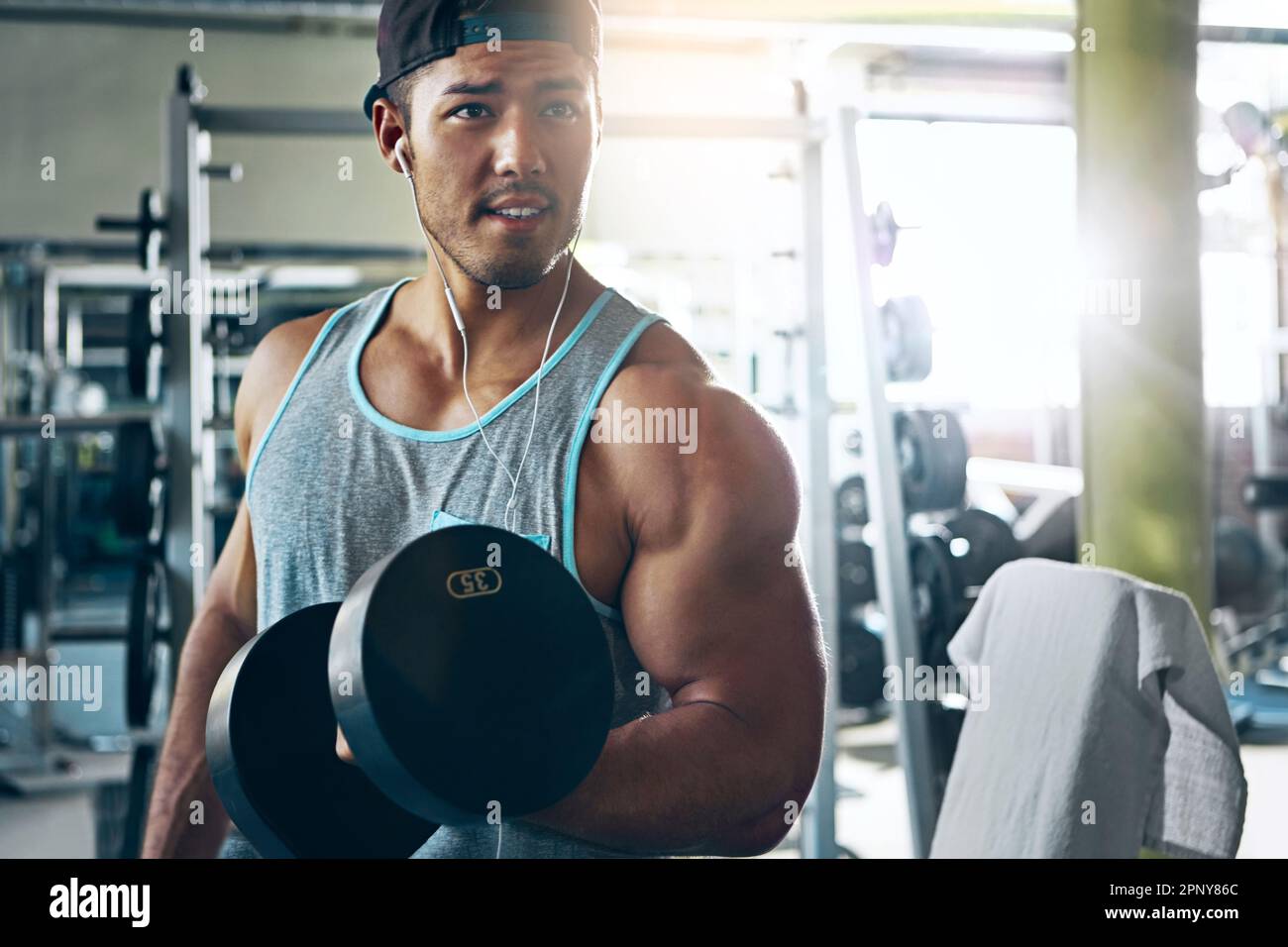 Sei nicht gleich, sei besser. Ein Mann, der im Fitnessstudio Gewichte trainiert. Stockfoto