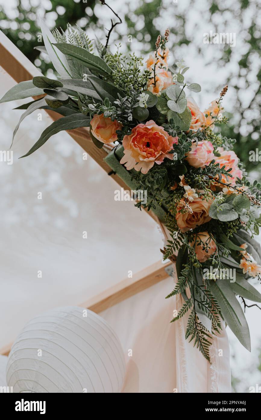 Sommerzeit Hochzeit Baldachin Details von Light Orange Blumen Stockfoto