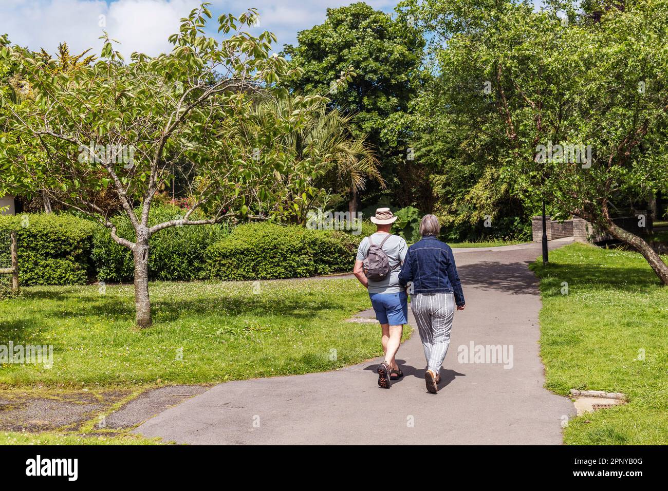 Ein Paar, das einen gemütlichen Spaziergang durch die Trenance Gardens in Newquay in Cornwall in England, Großbritannien, genießt. Stockfoto