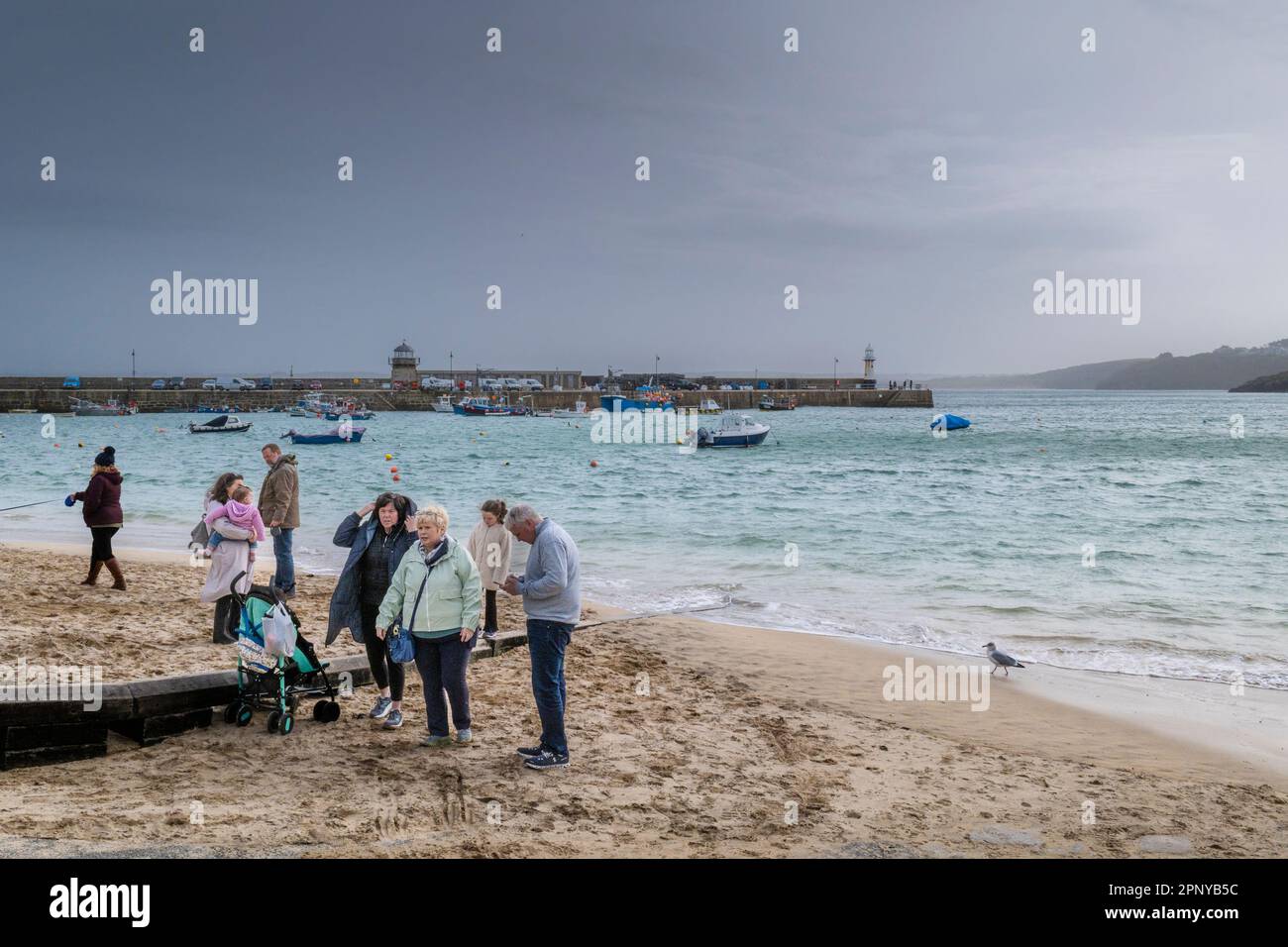 Wetter in Großbritannien. Besucher am Strand an einem regnerisch kalten, elenden Tag in der historischen Küstenstadt St. Ives in Cornwall, England, im Vereinigten Königreich. Stockfoto