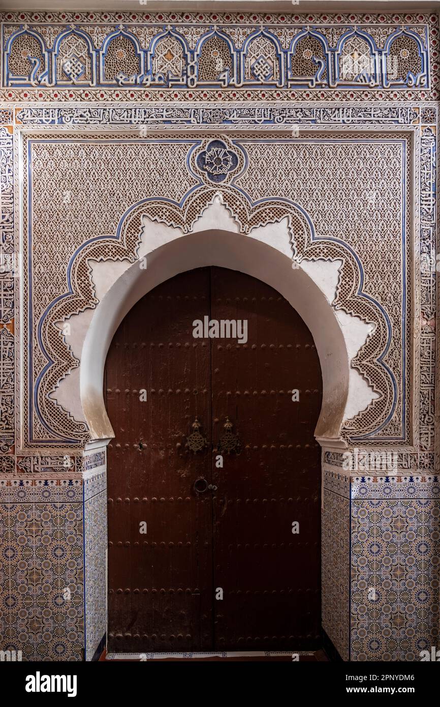 Eingangstür zu einer kleinen Moschee mit arabischen Ornamenten in der Medina von Marrakesch. Stockfoto