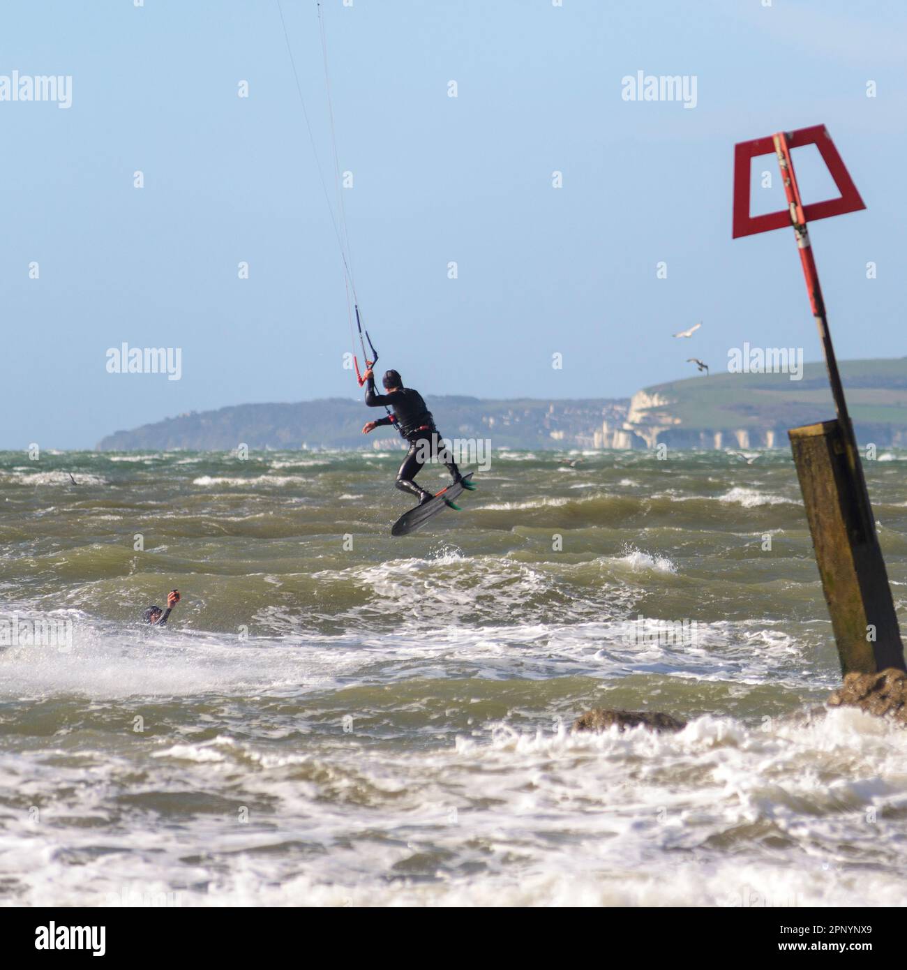 Kitesurfer in der Luft, die bei starkem Wind von Storm Noa, Bournemouth, Dorset, England, Großbritannien, 12. April 2023 Stockfoto