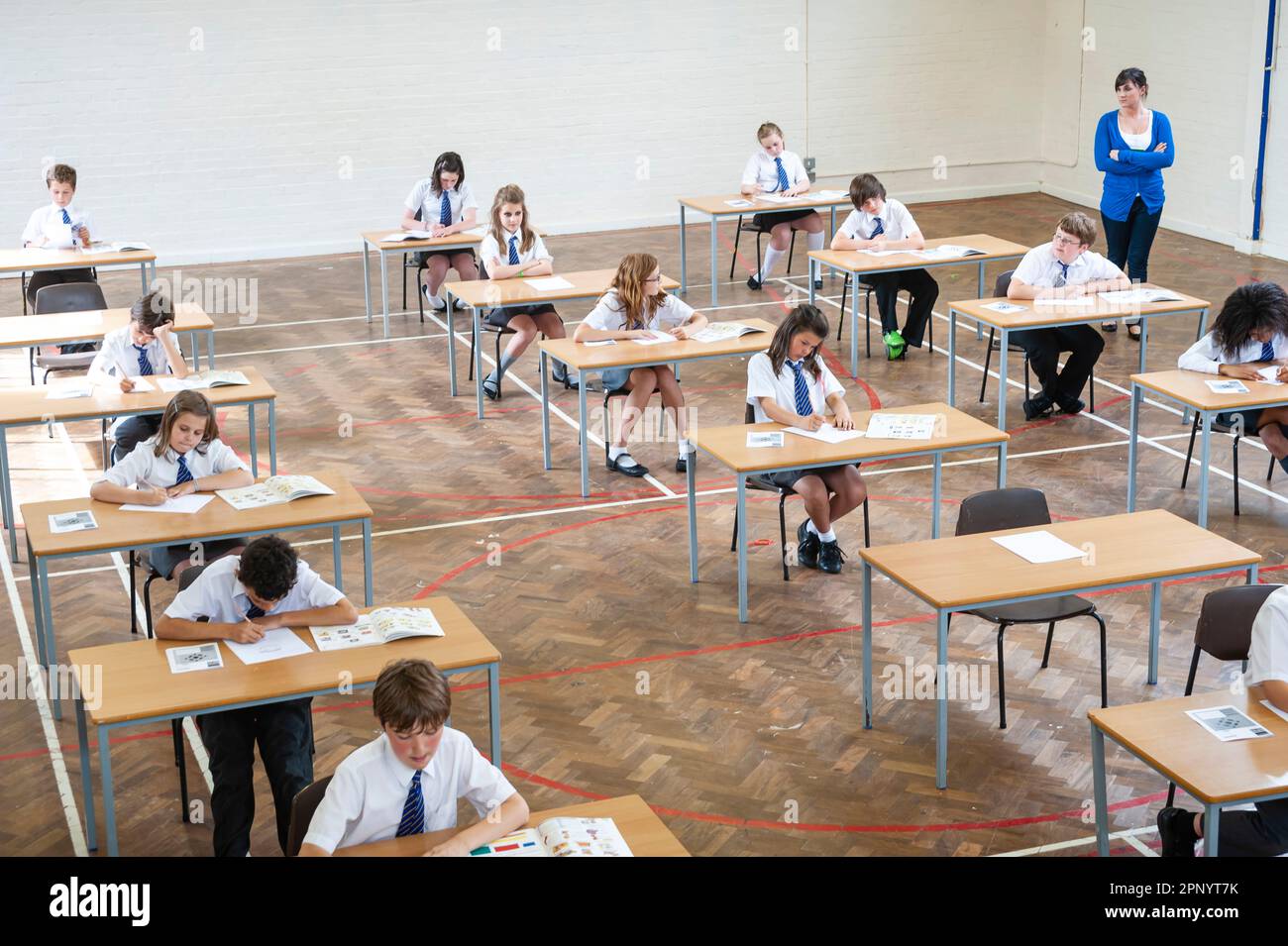 Schüler in der Schulhalle, unter Prüfungsbedingungen, die ihre Prüfungen zum Jahresende ablegen Stockfoto