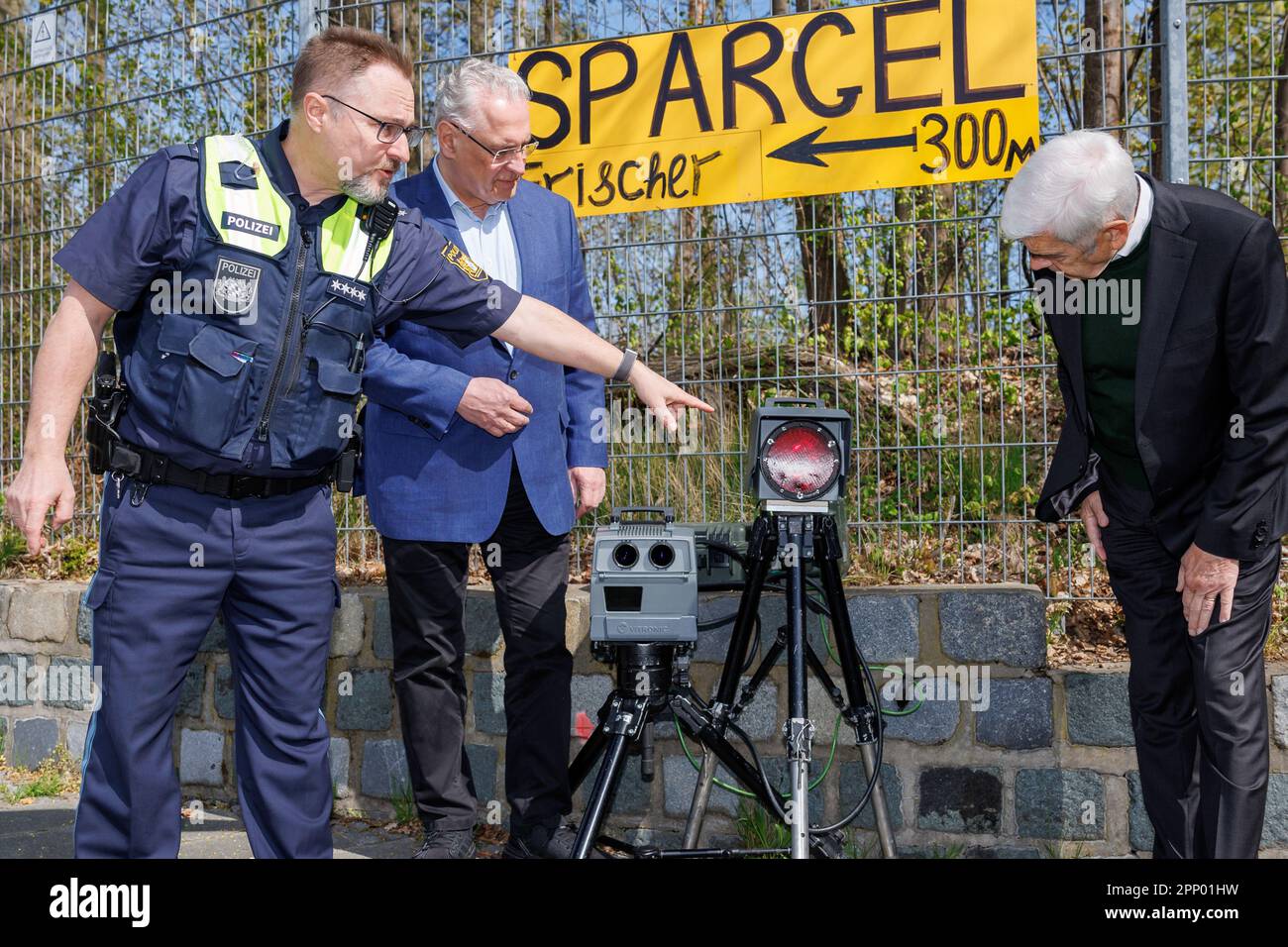 21. April 2023, Bayern, Nürnberg: Chefinspektor Dirk Klinge (l), Leiter der Nürnberger Verkehrspolizei, erläutert, wie das Geschwindigkeitsmesssystem PoliScan FM1 von Vitronic an den bayerischen Innenminister Joachim Herrmann (M, CSU) und den stellvertretenden Vorsitzenden der bayerischen Verkehrspolizei Wolfgang Gerstberger während des sogenannten "Blitzmarathon" funktioniert. An rund 1800 Messpunkten in ganz Bayern halten die Polizei und die Mitarbeiter der Gemeinden sowie die kommunale Verkehrsüberwachung Ausschau nach Schnellfahrern. Vor allem aber werden auch dort Kontrollen durchgeführt, wo die r Stockfoto