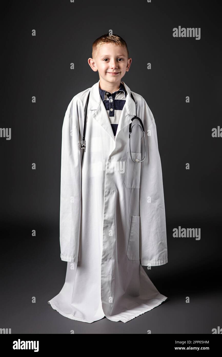 Kind mit Erwachsenenarztmantel, Studioaufnahme Stockfoto