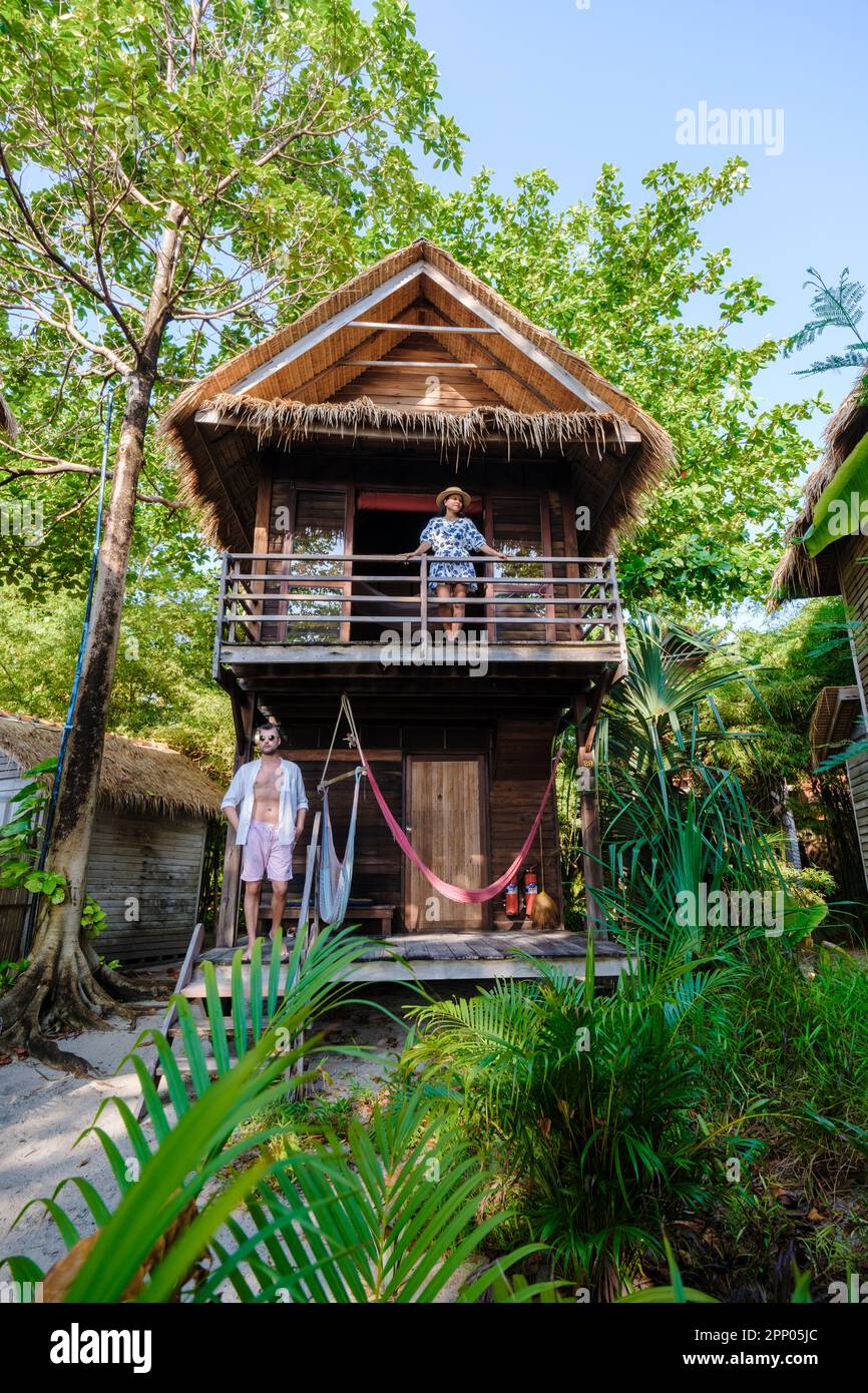 Bungalow am Strand einer Insel in Thailand, eine Holzvilla am Strand mit Palmen, ein Paar im