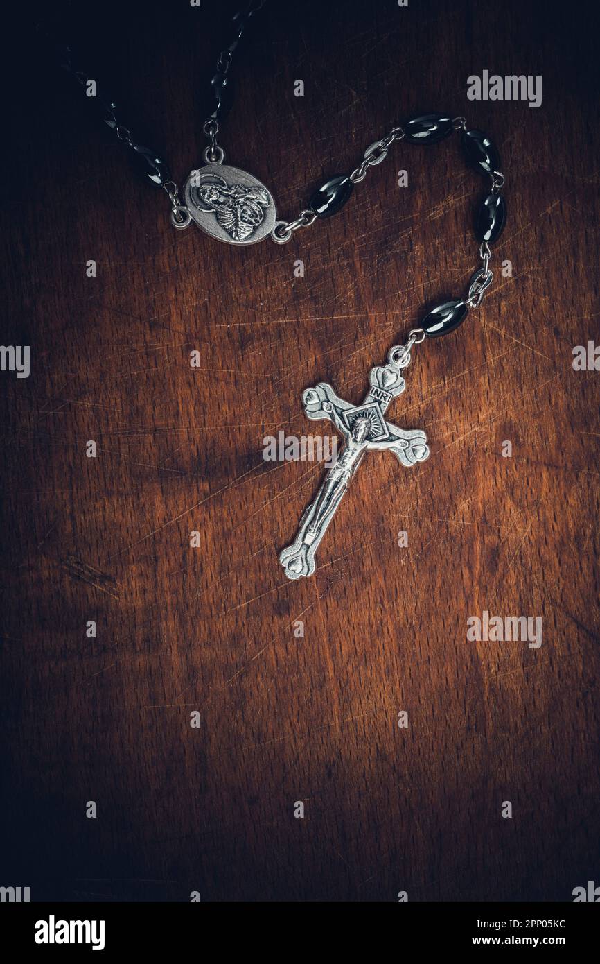 Rosenkranz aus Metall mit Kreuz auf Holzhintergrund Stockfoto