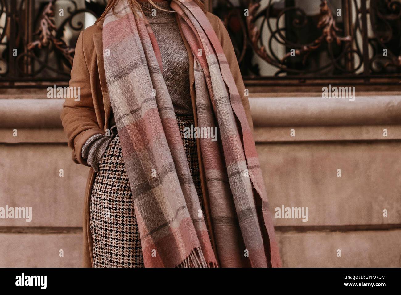 Frau im Herbst stilvoll Braun langer Mantel, Schal und karierte Hose auf  einem Spaziergang durch die Stadt. Lässiges Outfit für Damen im Street-Stil  Stockfotografie - Alamy