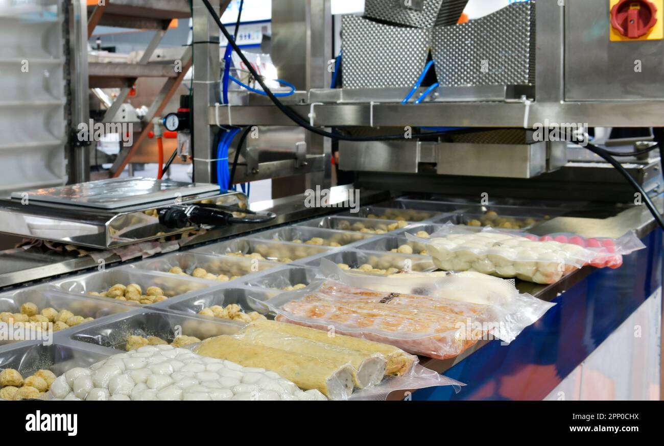 Automatisches Huhn, Schweinefleisch, Scheiben Frischfleisch, Produktionslinie für Lebensmittel auf Förderbandmaschinen in der Fabrik, industrielle Lebensmittelproduktion Stockfoto