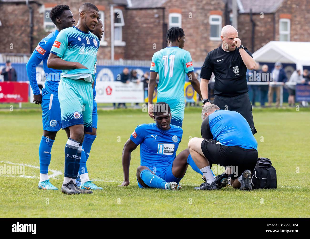 Colin Oppong wird bei einem Fußballspiel gegen Stalybridge Celtic in Gorsey Lane, Warrington, Cheshire wegen einer Verletzung des Knöchels behandelt Stockfoto