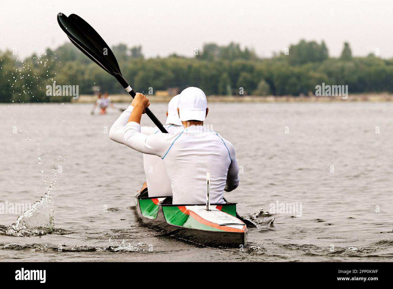 Rückansicht zwei männliche Kajakfahrer im Kajak-Double beim Kajakwettbewerb, Sportspiele im Sommer Stockfoto