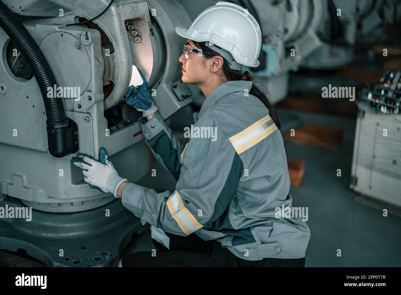 Ein erfahrener Robotertechniker erkennt das Licht auf Roboterkomponenten, um Schutz- und Korrekturwartungen durchzuführen. Inspektion komplexer mechanischer Systeme. R Stockfoto