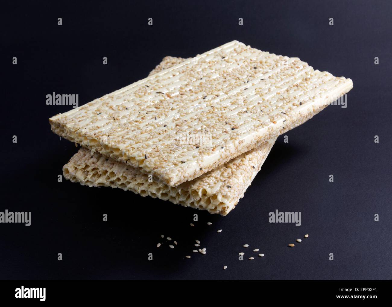 Sesamsamen-Honigriegel isoliert auf schwarzem Hintergrund. Sesamsamen-Kozinaki. Sesamum indicum L. Tiler Khaja Stockfoto