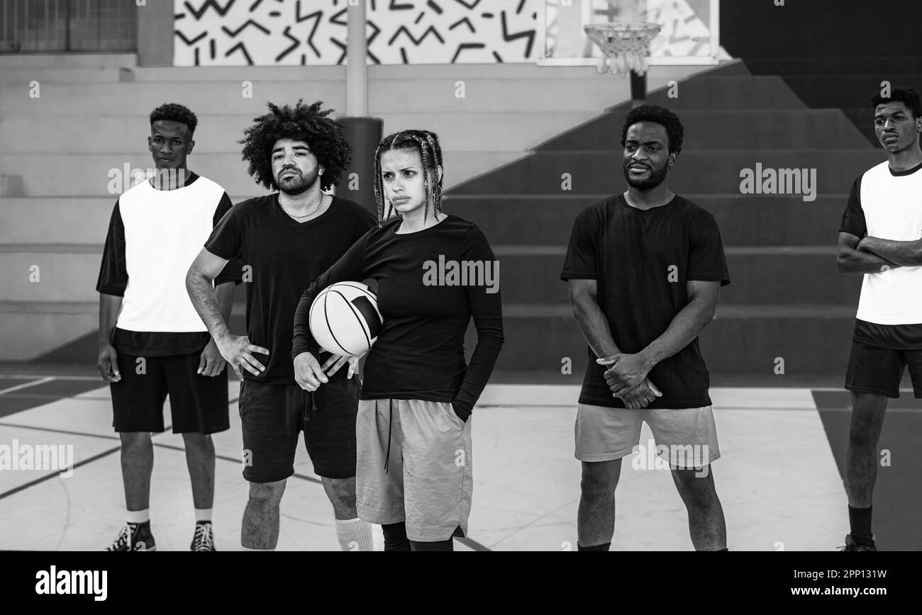Gruppe von Menschen mit mehreren ethnischen Gruppen, die Spaß beim Basketballspielen im Freien haben - Urban Sport Lifestyle-Konzept - Schwarz-Weiß-Bearbeitung Stockfoto