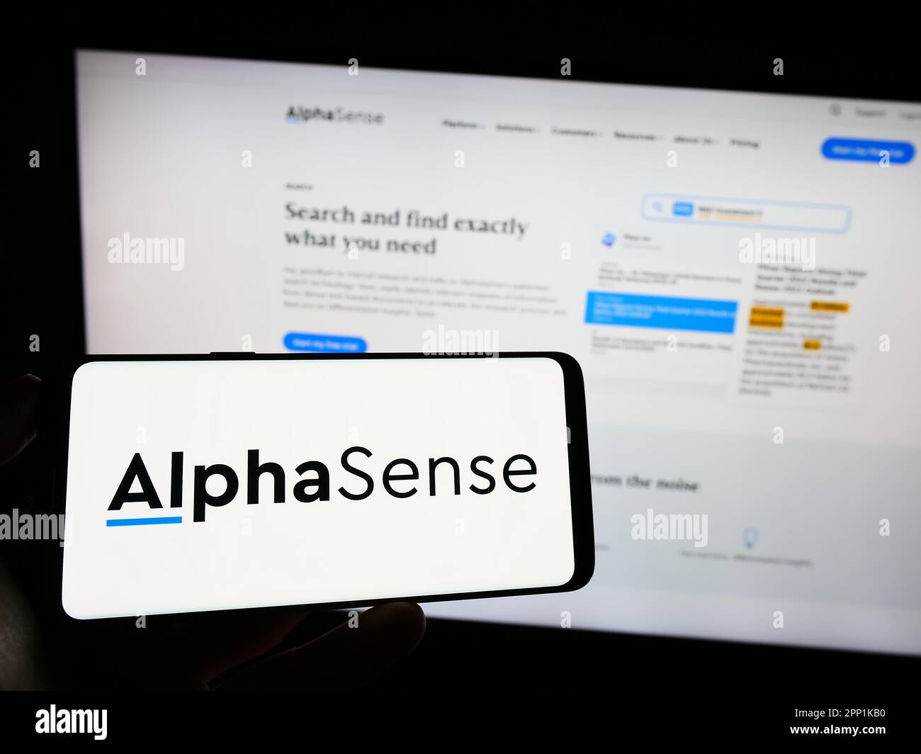 Person, die ein Mobiltelefon mit dem Logo des amerikanischen Marktforschungsunternehmens Alphasense Inc. Auf dem Bildschirm vor der Webseite hält. Konzentrieren Sie sich auf das Display des Telefons. Stockfoto