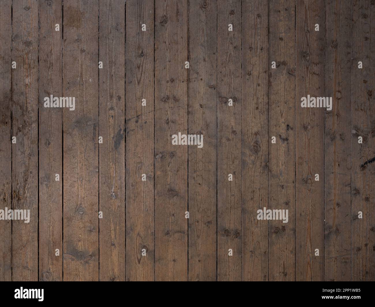 Alte Holzbodenfußböden. Verwitterte Dielen in dunkelbrauner Farbe und vertikaler Ausrichtung. Hintergrund der Holzkornstruktur. Stockfoto