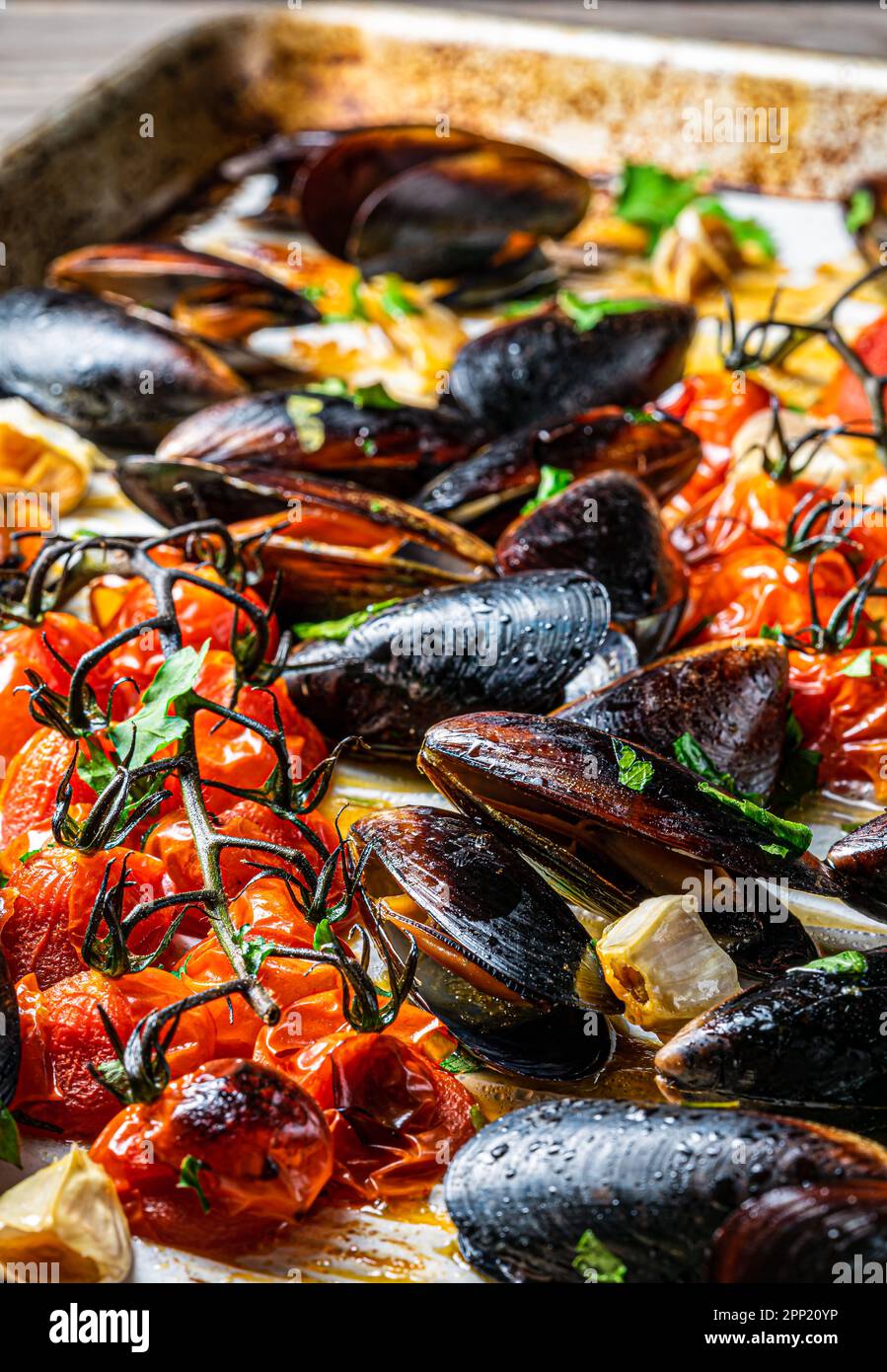 Gebackene Muscheln mit Knoblauch und Tomaten. Über Schuss. Stockfoto