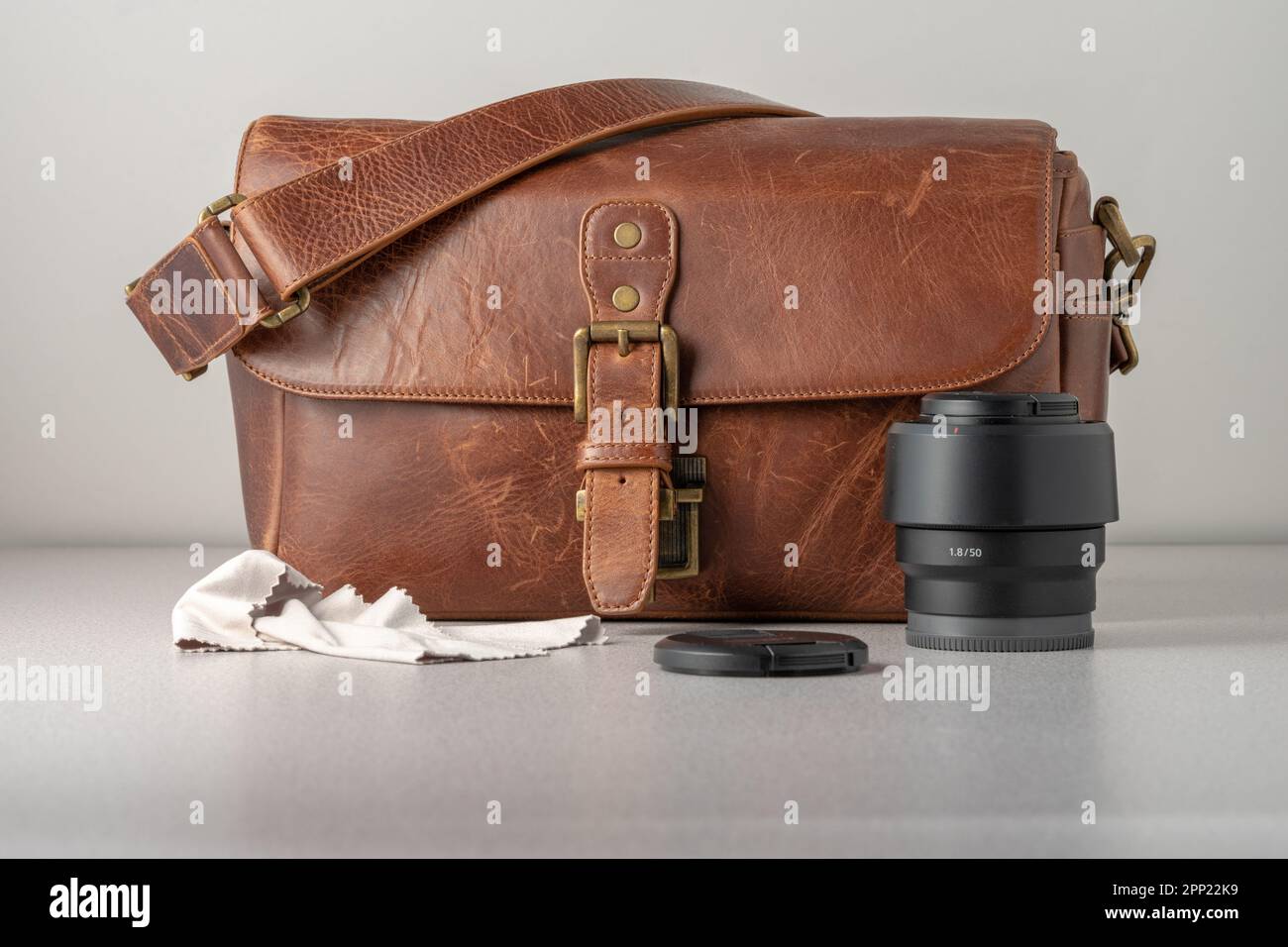 Kameratasche aus braunem Leder. 50mm-mm-Objektiv an der Vorderseite. Kopf auf Schuss. Stockfoto