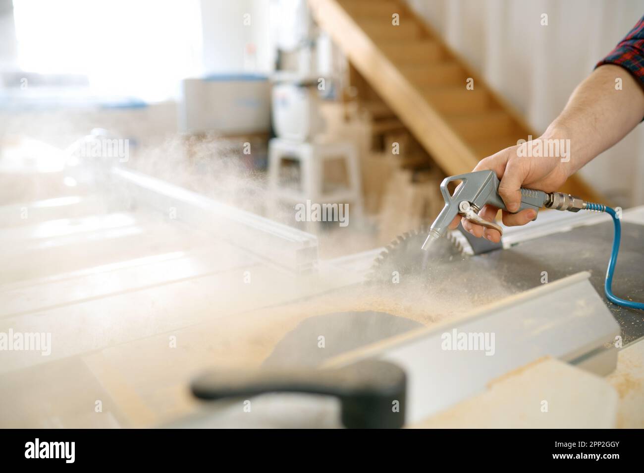Nahaufnahme von Tischlerhänden beim Abwaschen von Sägemehl von der Holzbohle Stockfoto